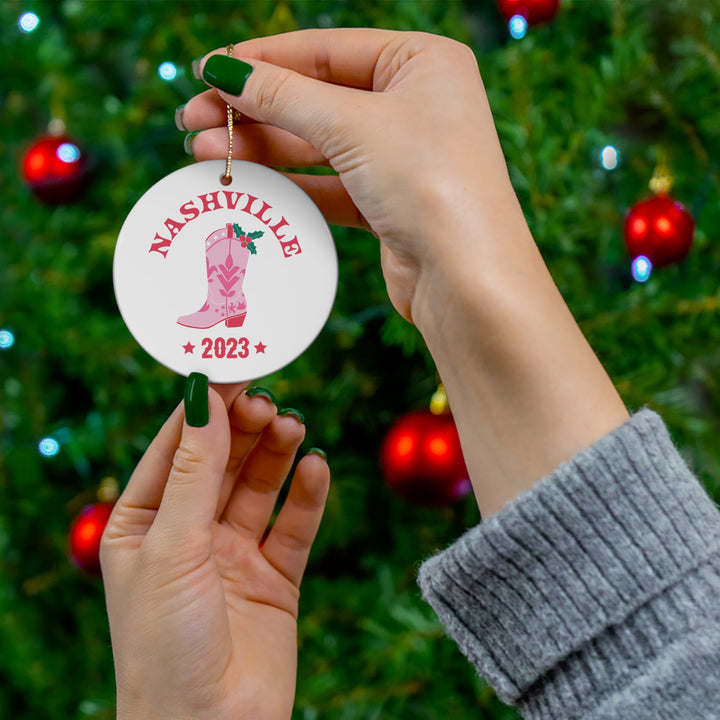 Vibrant pink Nashville 2023 Cowgirl Boot Ornament featuring festive holly leaves, perfect for Nashville and country music lovers